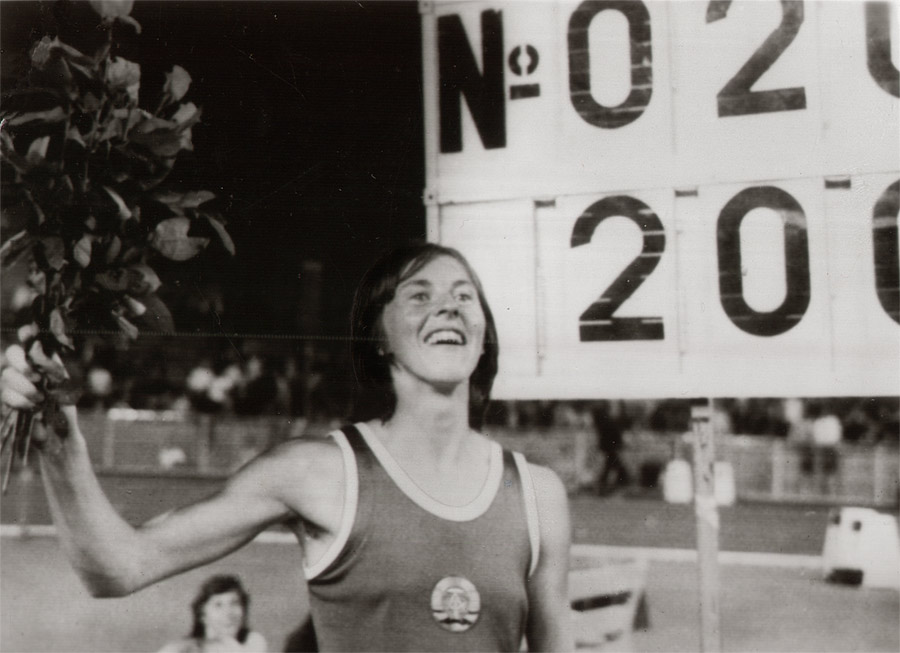 Fotografie von Rosemarie Ackermann in Leichtathletik-Trikot der DDR mit Blumenstrauß in der Hand