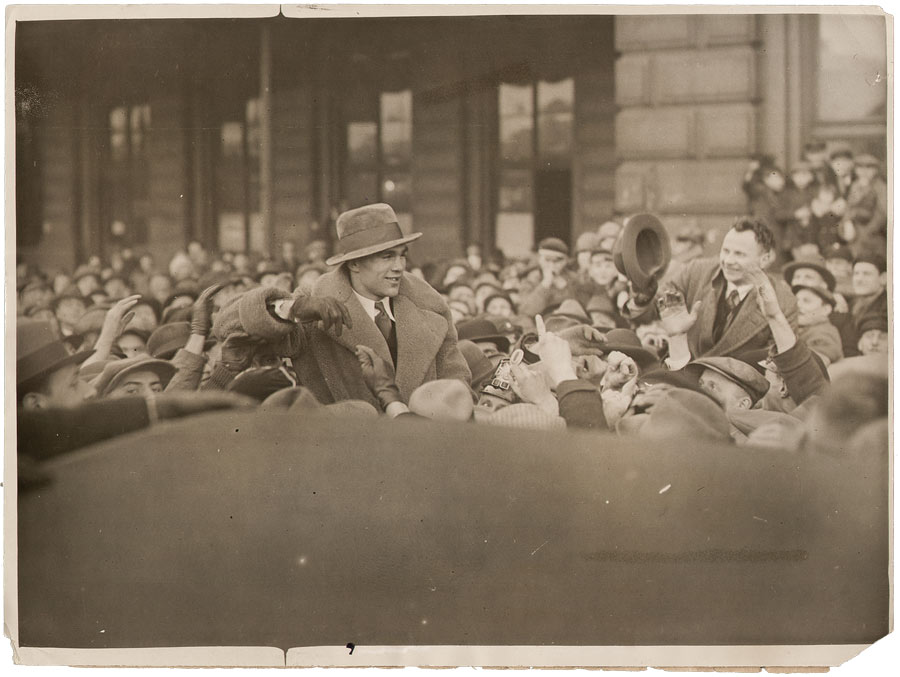 Max Schmeling mit Mantel und Hut in Menschenmenge