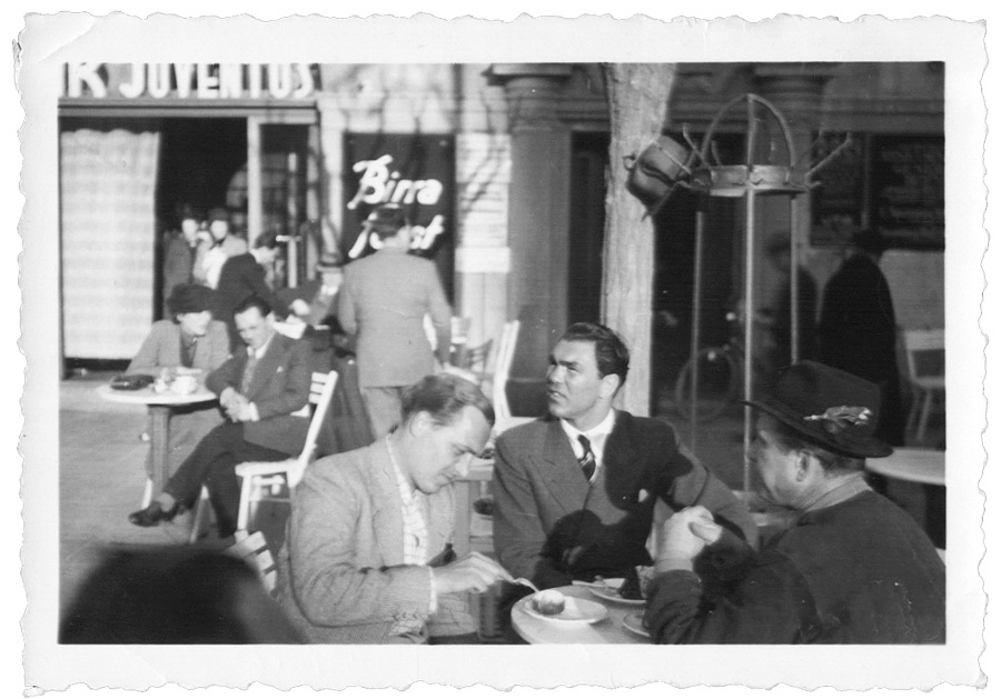 Max Schmeling mit zwei Begleitern an einem Tisch sitzend
