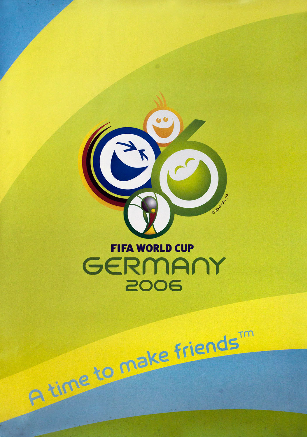Plakat mit Abbildung des offiziellen Logos der Fußball-Weltmeisterschaft 2006 in Deutschland. Dieses besteht aus drei lachenden Smileys sowie einem stilsierten Weltmeisterpokal