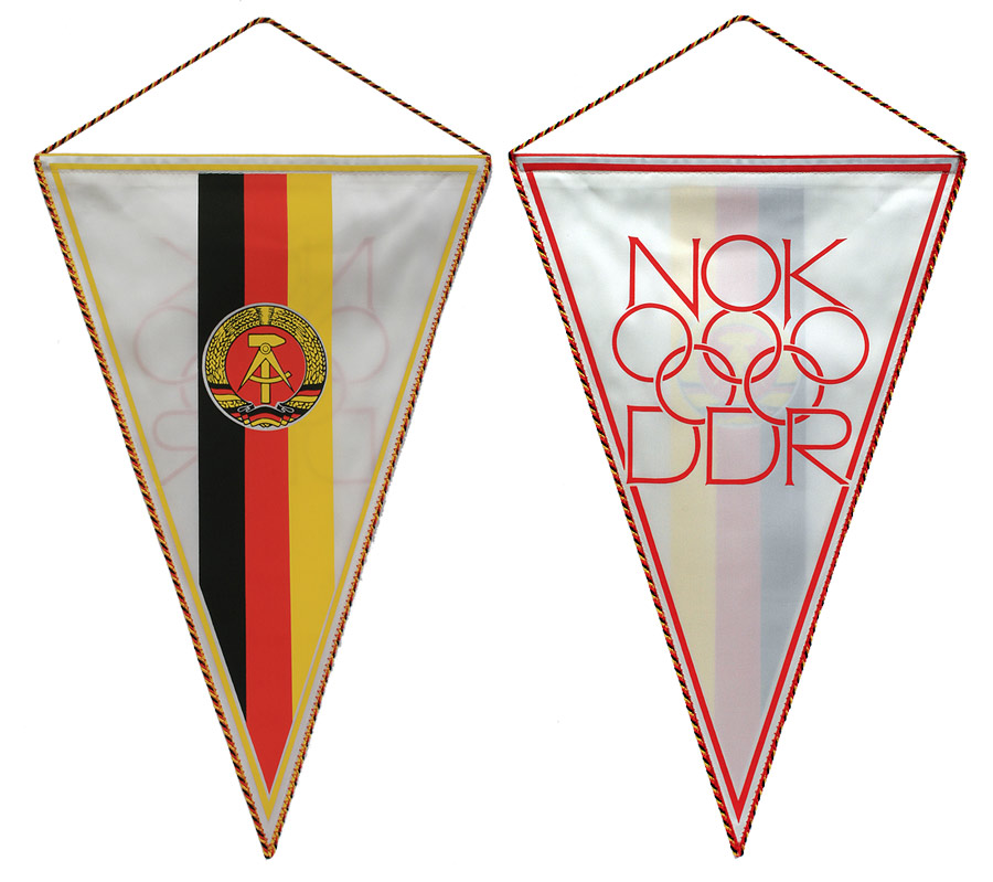 Wimpel mit Abbildung der Flagge der DDR auf der Vorderseite und olympischen Ringen und Schriftzug auf der Rückseite