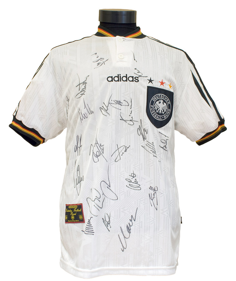 Weißes Fußballtrikot mit dem Logo der deutschen Fußball-Nationalmannschaft und zahlreichen Autogrammen