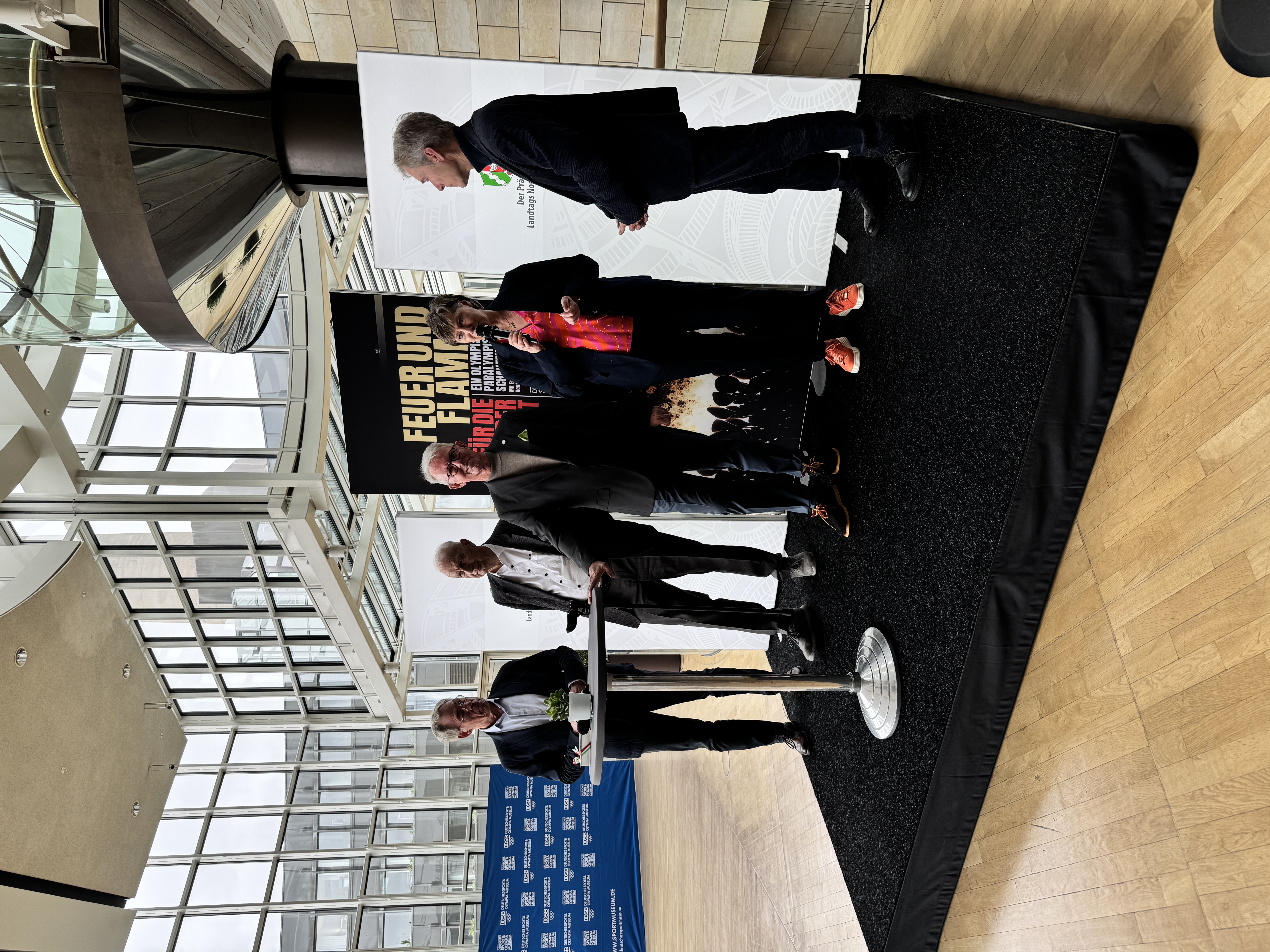 Auf dem Podium sind fünf Personen zu sehen.