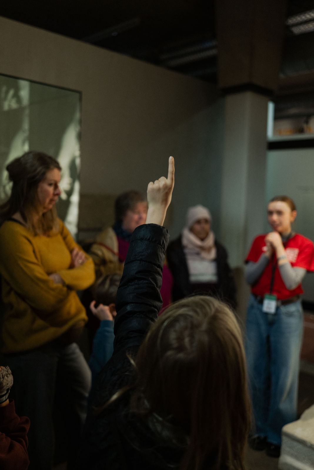 Auf dem Foto sind mehrere Personen bei einer Führung zu sehen. Der Museumsguide steht vor einer Herkules-Statue.