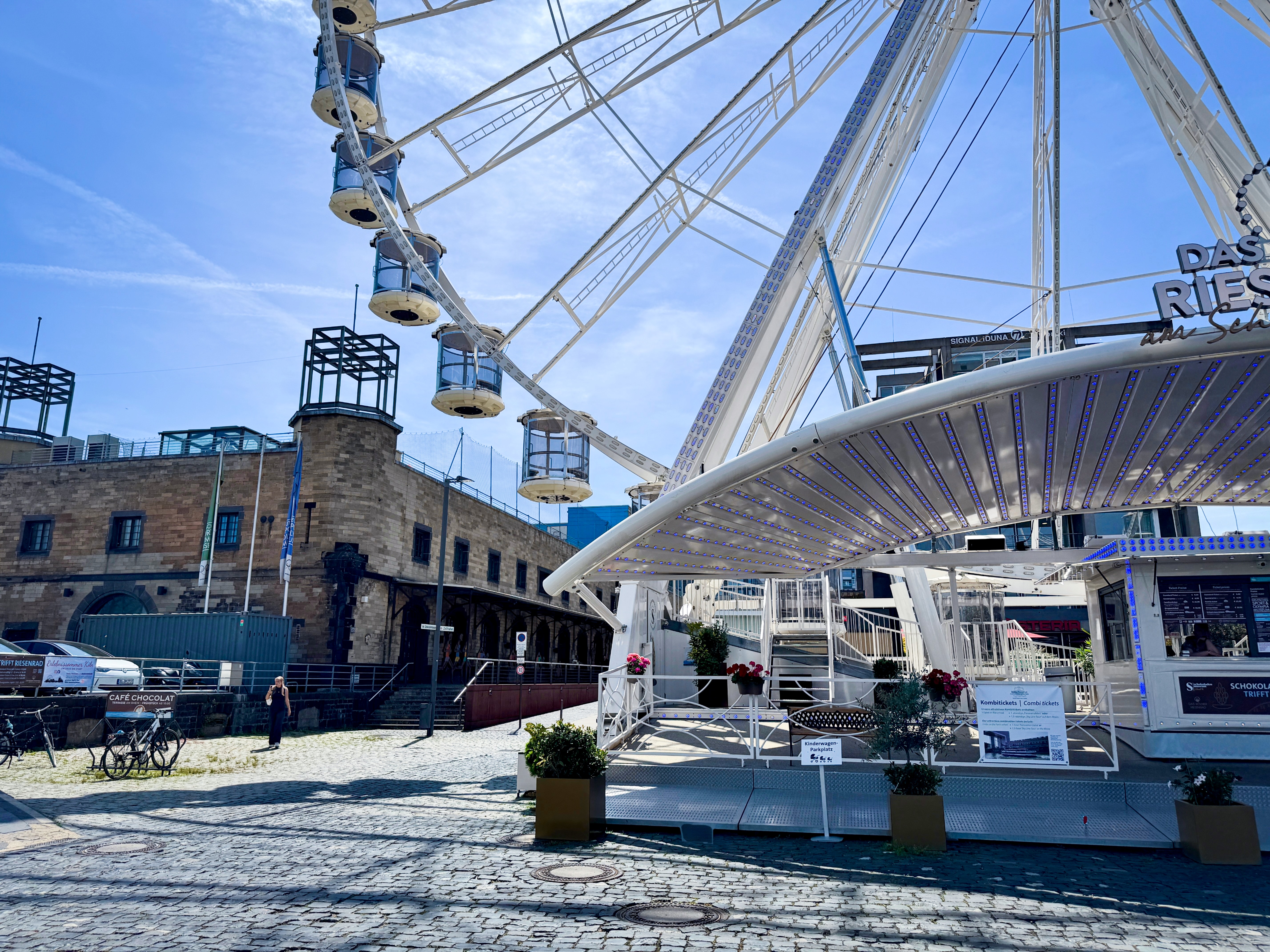 Auf dem Foto ist rechts das Kölner Riesenrad und links ein Ausschnitt des Deutschen Sport & Olympia Museums zu sehen.