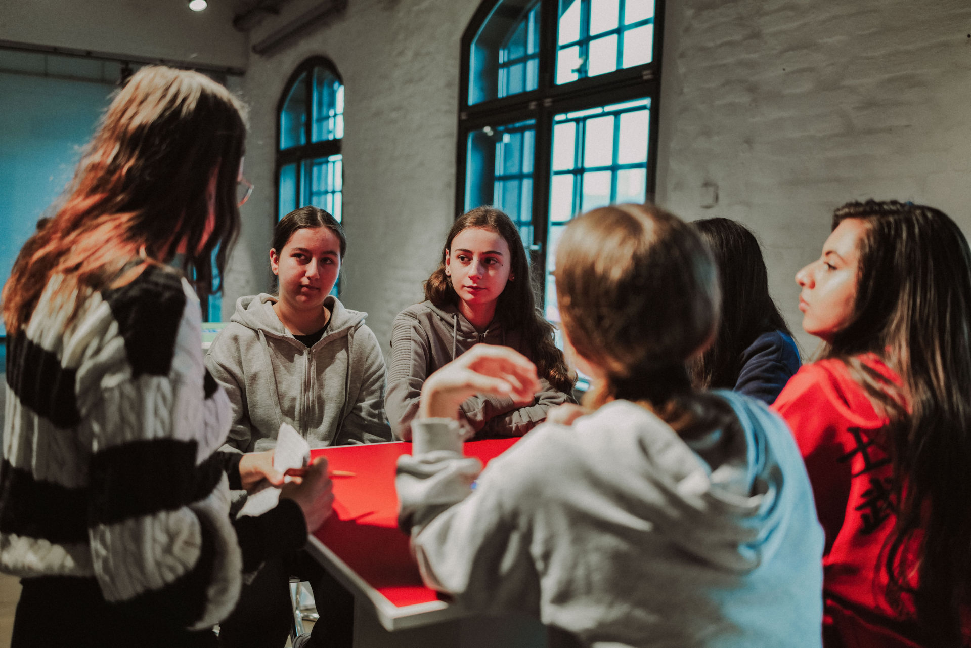 Mehrere junge frauen diskutieren an einem Tisch.
