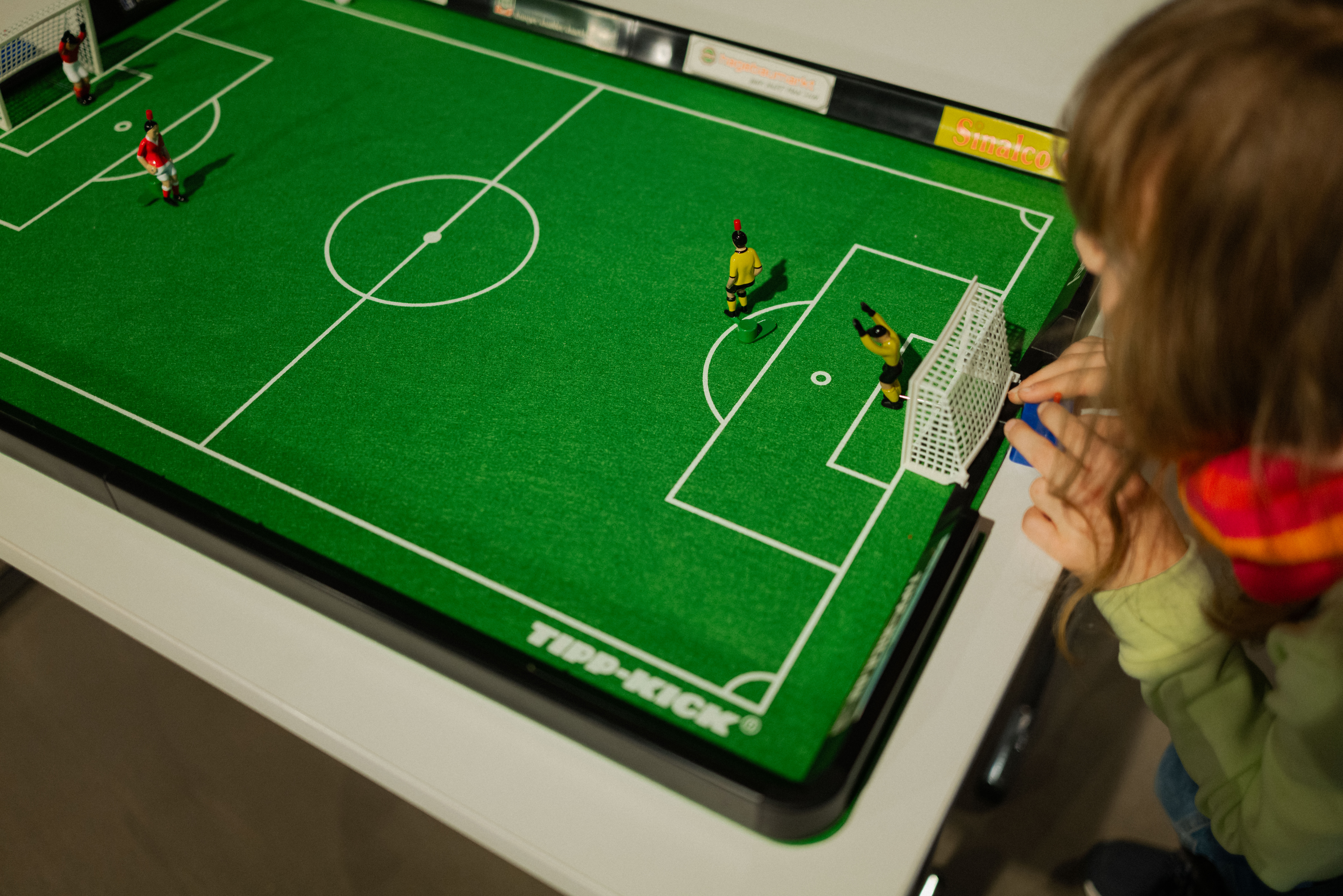 Kinder spielen mit einem Tisch-Fußball.