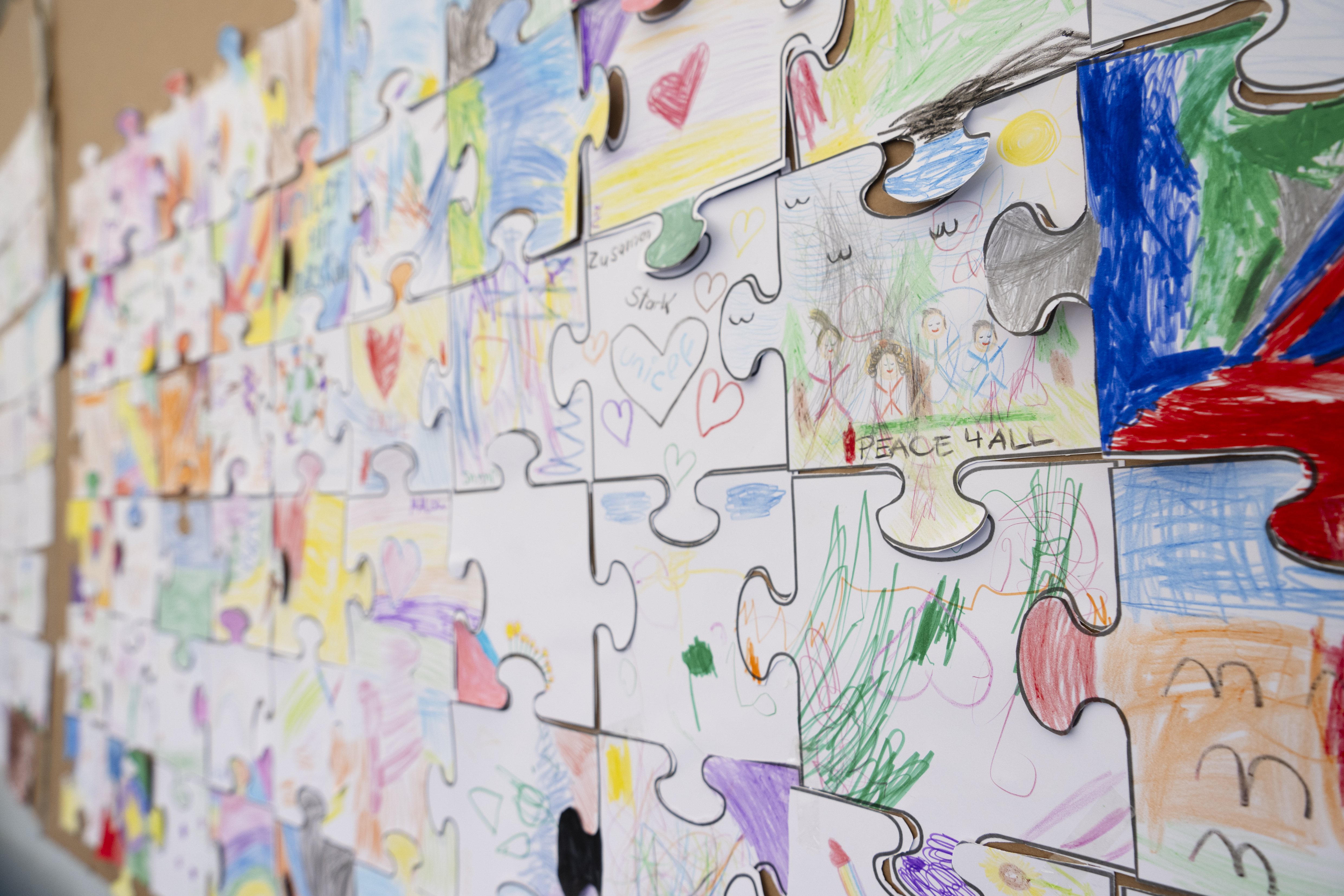 Kleine Bilder sind an einer Wand wie ein Puzzle angeordnet.