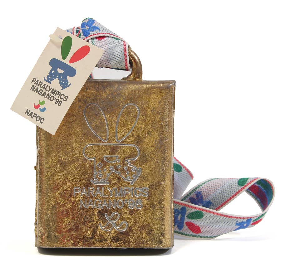 Goldene Glocke an weißem Band mit farbigen Elementen