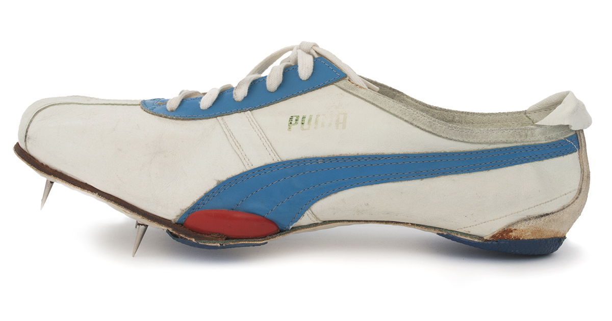 Weißer Sportschuh mit blauem Streifen und Spikes