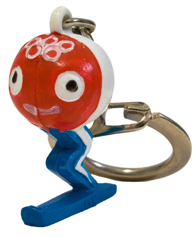 Figur eines stilisierten Skifahrers im blauen Skianzug mit roter Kugel als Kopf