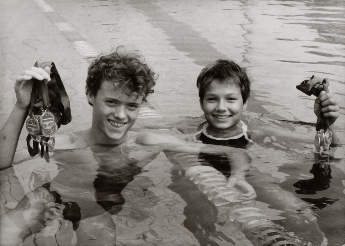 Fotografie in Schwarz und Weiß von Jörg Hoffmann und Franziska van Almsick im Schwimmbecken mit jeweils mehreren Medaillen in der Hand