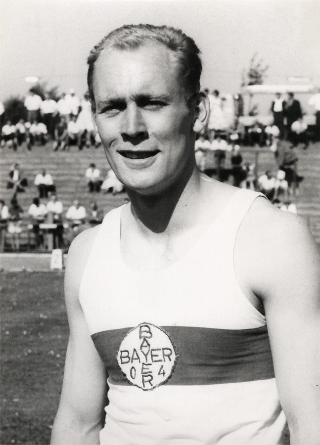 Fotografie in Schwarz und Weiß von Willi Holdorf mit Logo des TSV Bayer 04 Leverkusen auf der Brust